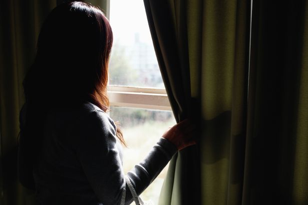 Mature-woman-looking-out-of-window-side-view