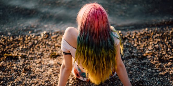 woman-sitting-shore-rainbow-hair