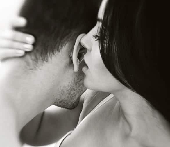 seductive-woman-in-the-arms-of-a-man-whispering-in-his-ear-min